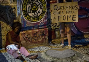 a-protester-stands-next-to-a-homeless-woman-with-a-placard-reading-we-want-a-cure-for-hunger1470594091
