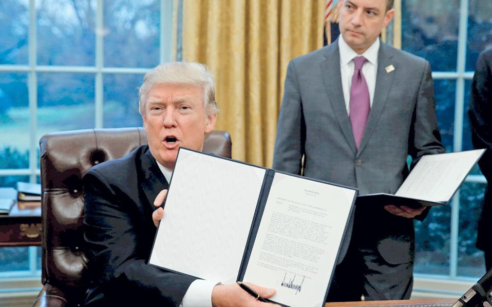 Πρεμιέρα με κινήσεις προστατευτισμού για τον Ντόναλντ Τραμπ στον Λευκό Οίκο. Ο νέος Αμερικανός πρόεδρος υπέγραψε διάταγμα με το οποίο οι ΗΠΑ αποσύρονται από τις διαπραγματεύσεις για τη δημιουργία ζώνης ελευθέρου εμπορίου στον Ειρηνικό Ωκεανό (ΤΡΡ), για την οποία είχε πρωτοστατήσει η κυβέρνηση Ομπάμα. Νωρίτερα, ο Τραμπ είχε καλέσει τον Καναδά και το Μεξικό σε επαναδιαπραγμάτευση της ισχύουσας συμφωνίας ελευθέρου εμπορίου στη Βόρεια Αμερική (NAFTA). Στη φωτογραφία, ο Αμερικανός πρόεδρος επιδεικνύει το διάταγμα που έδωσε τη χαριστική βολή στην ΤΡΡ. 