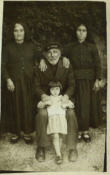 «Η γιαγιά μου (δεξιά) και η αδερφή του μπαμπά μου. Η φωτογραφία τραβήχτηκε στις αρχές της δεκαετίας του 1940 την εποχή της ιταλικής κατοχής, λίγο πριν να μεταναστεύσει ο παππούς μου στην Αμερική για να ζήσει την οικογένεια. Οι γυναίκες τότε δε χαμογελούσαν ποτέ στις φωτογραφίες.» Από το αρχείο της Ιβέτ Μάνεσις Κορπορόν.