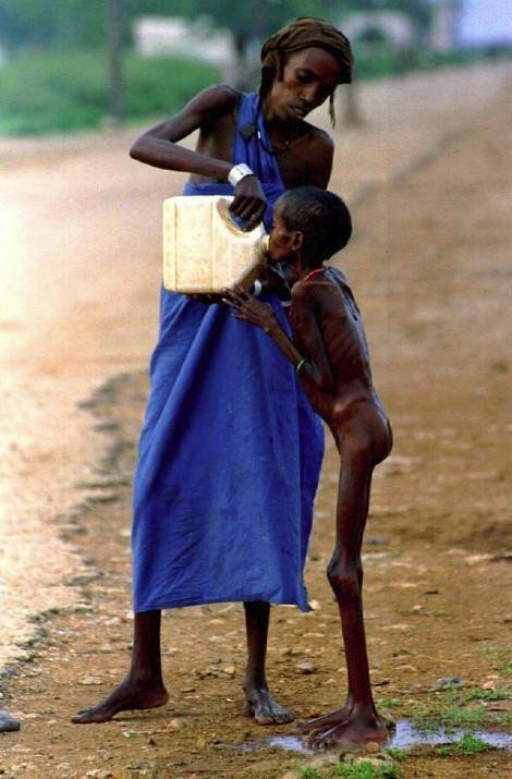 Μια γυναίκα δίνει νερό σε παιδί που λιμοκτονεί στην Σομαλία