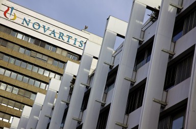 A sign sits on the side of the Novartis AG headquarters in Basel, Switzerland, on Monday, Jan. 23, 2012. Novartis, Europe's second-biggest drugmaker by sales, will boost its payout to shareholders by 9.1 percent to 2.40 Swiss francs, according to Bloomberg Dividend Forecasts that are based on earnings and options prices. Photographer: Gianluca Colla/Bloomberg