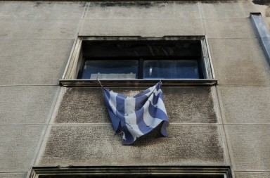 A tattered greek flag is hanging from a building window, in Athens, Dec. 22, 2014 / Μια κουρελιασμένη ελληνική σημαία κρέμεται απο το παράθυρο ενός κτηρίου, στην Αθήνα, στις 22 Δεκεμβρίου, 2014