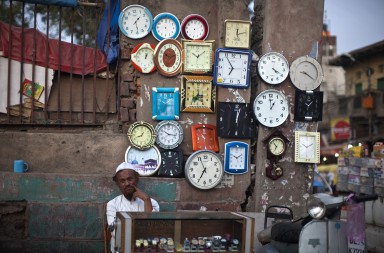 A roadside vendor waits for customers at his stall of clocks and watches in the old quarters of Delhi June 18, 2012. REUTERS/Ahmad Masood (INDIA - Tags: SOCIETY BUSINESS) - RTR33TMG