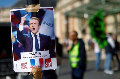 A placard with a portrait of French President Emmanuel Macron and the slogan "49.3, because it's my project" is seen near the railway station as French workers on strike gather to attend a demonstration on the eve of the ninth day of national strike and protests, and after the pension reform was adopted as the French Parliament rejected two motions of no-confidence against the government, in Nice, France, March 22, 2023. REUTERS/Eric Gaillard